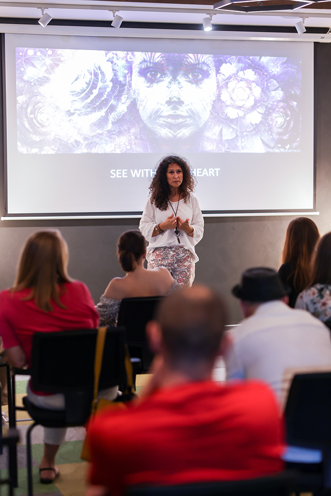 Andrea addressing the room in front of the See With Your Heart projection