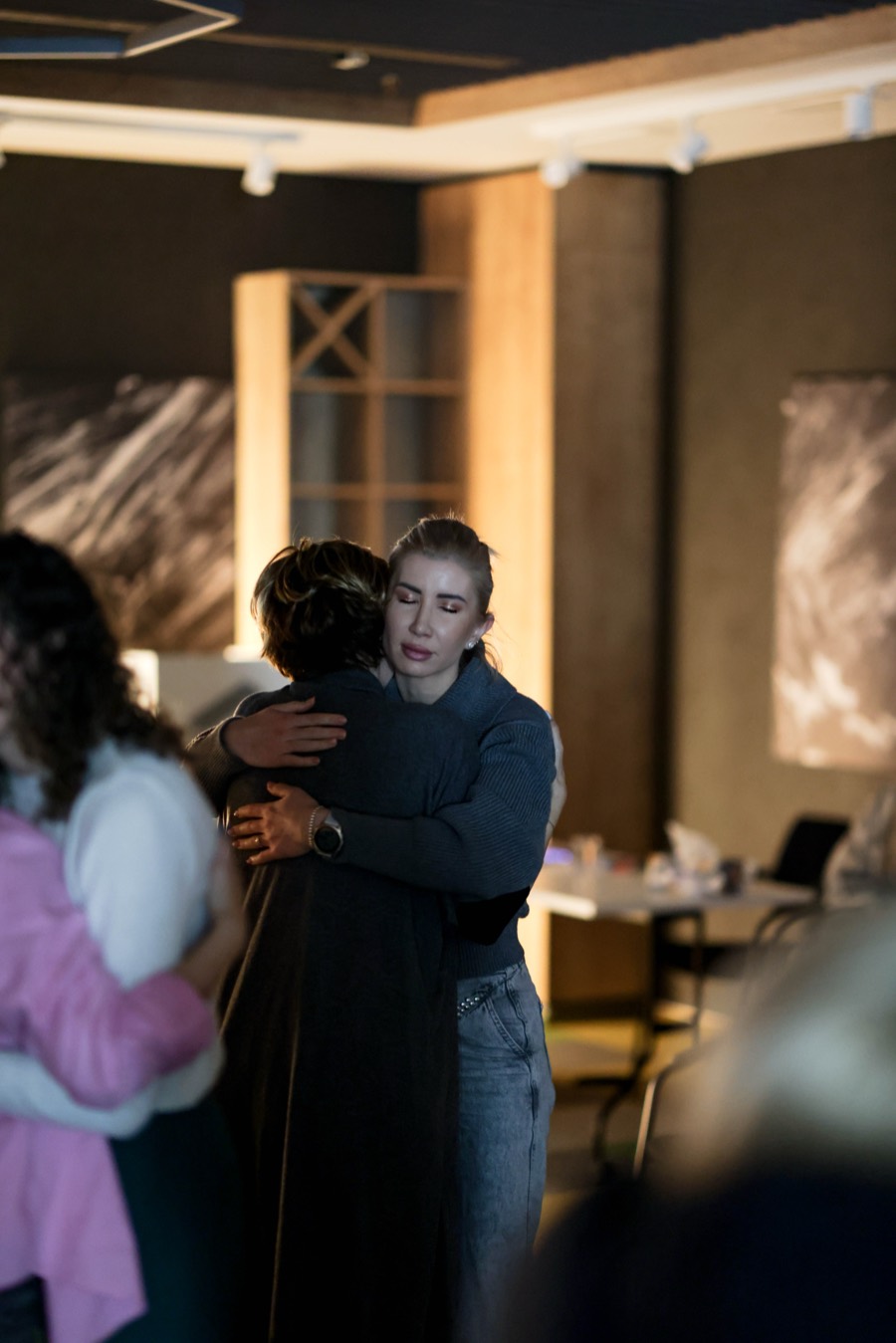 Two participants embracing in the middle of the room