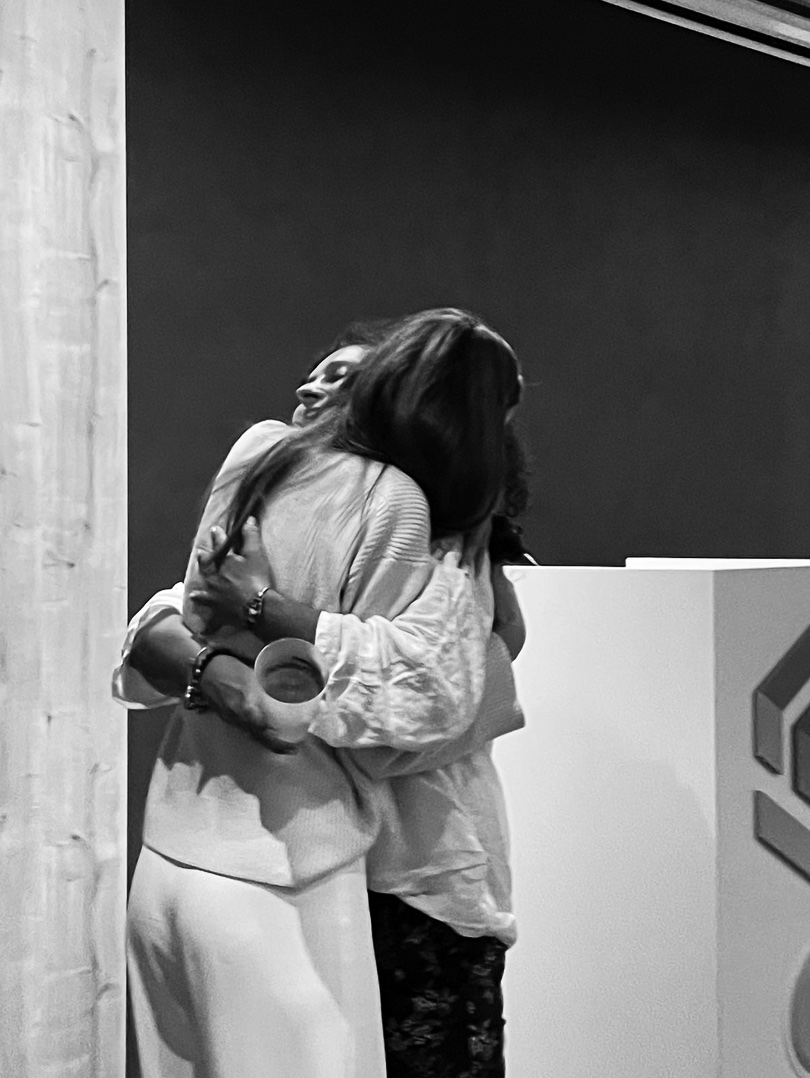 Two participants holding each other, one smiling over the other's shoulder