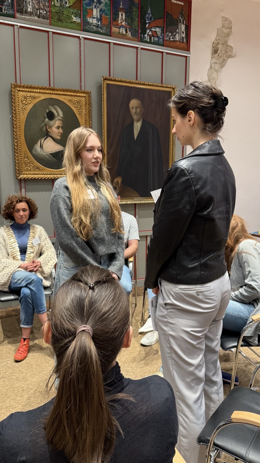 Two participants standing face to face while the group watches from the circle